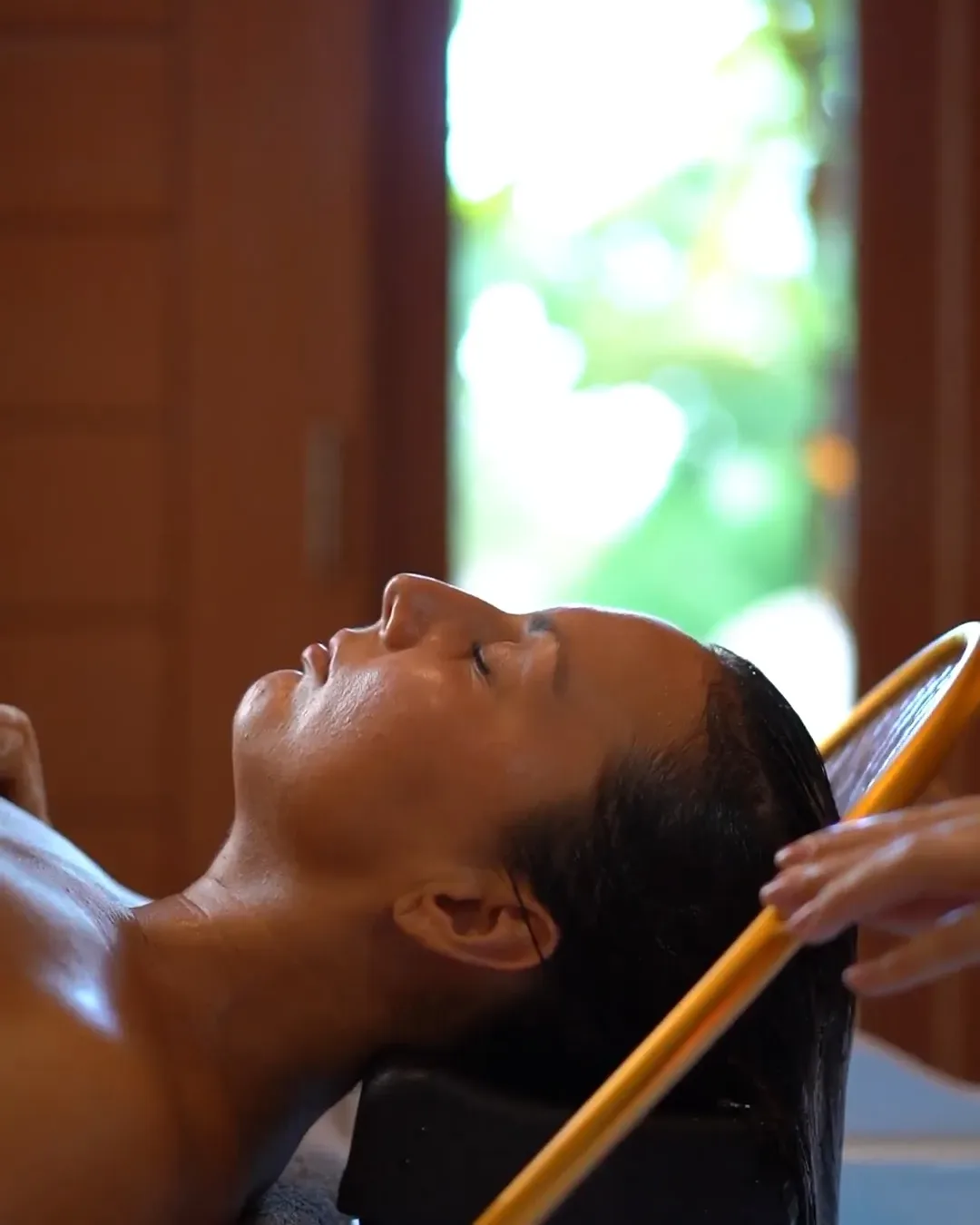 Femme allongée pendant une séance de Head Spa, la tête dans le bac de l'appareil Head Spa